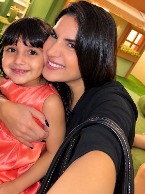 Anna Bueno abraçada à filha Georgia, as duas sorrindo para a câmera