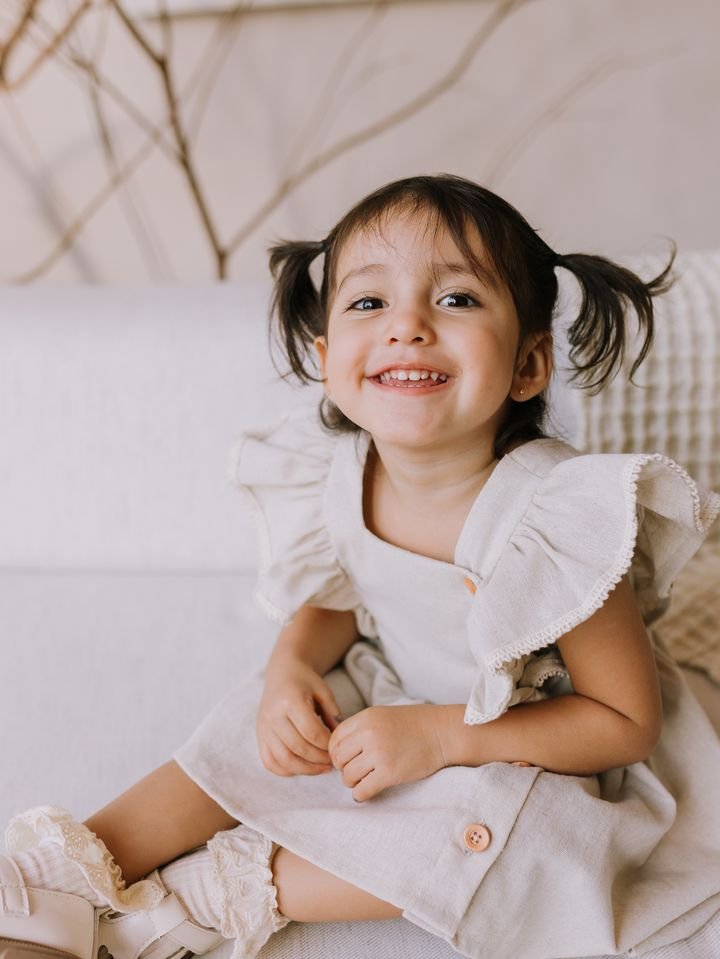 Georgia sorrindo, de vestido de linho e maria-chiquinha